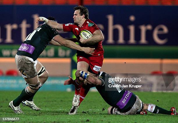 Andy Fenby of Scarlets is tackled by Clarke Dermody of London Irish during the LV= Cup match between Scarlets and London Irish at Parc y Scarlets on...