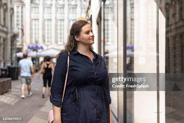 beautiful caucasian plus size woman window shopping on a sunny day - morbidly obese woman 個照片及圖片檔