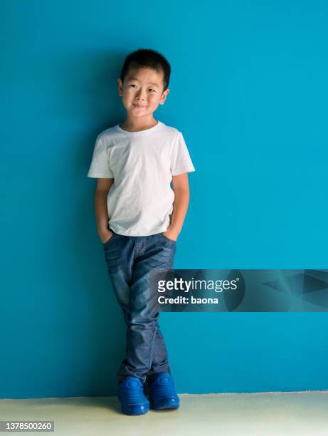 un ragazzo carino in piedi di fronte al muro blu - blue shoe foto e immagini stock