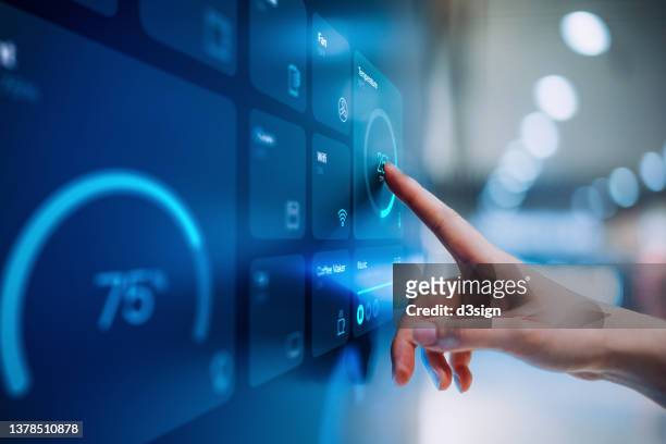 close up of woman's hand setting up intelligent home system, controlling smart home appliances with control panel of a smart home. home automated system controlled from a dashboard. smart living. lifestyle and technology. smart home technology concept - technology ストックフォトと画像