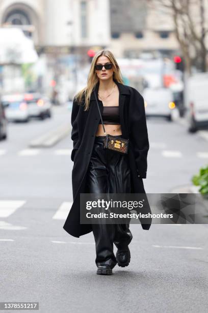 Influencer Alessa Winter wearing a black long coat by The Frankie Shop, a dark brown bralette by Weekday, black leather wide leg pants by Samsoe...