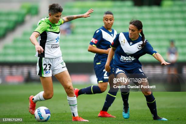 Michelle Heyman of Canberra United runs with the ball under pressure from Claudie Bunge of Melbourne Victory during the round 14 A-League Women's...