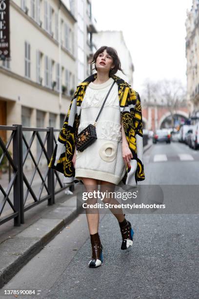 Influencer Lea Naumann wearing a black and yellow coat with key print by Louis Vuitton, a cream colored knitted mini dress by Louis Vuitton,...