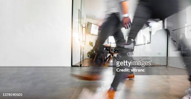 geschäftsleute gehen durch den büroflur - blurry office stock-fotos und bilder