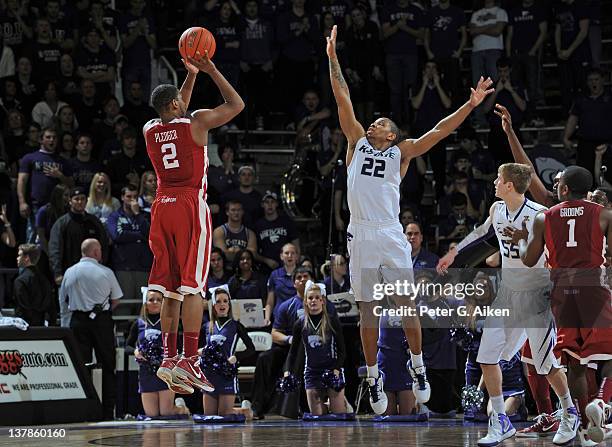 Guard Steven Pledger of the Oklahoma Sooners hits a three-point shot over guard Rodney McGruder of the Kansas State Wildcats during the second half...