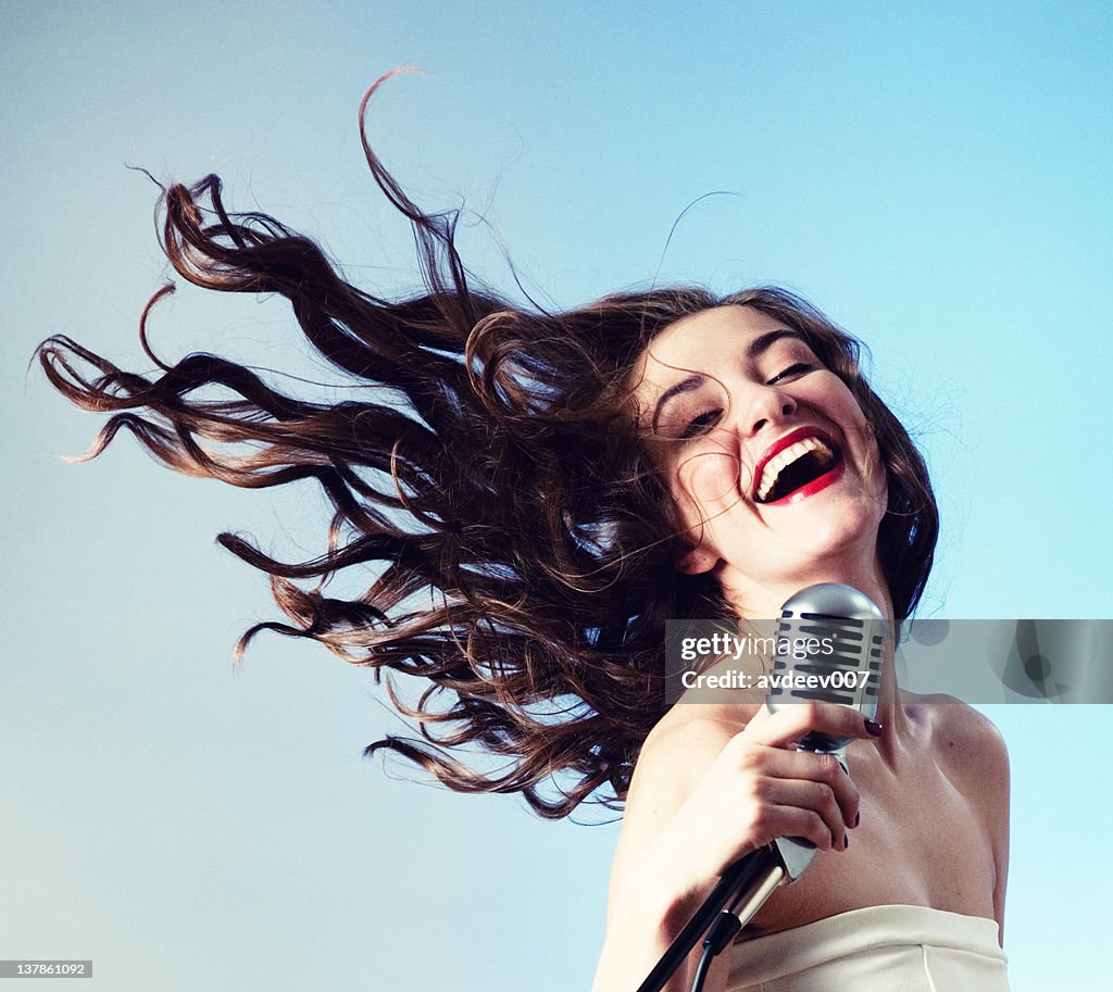 Woman Singing into Microphone