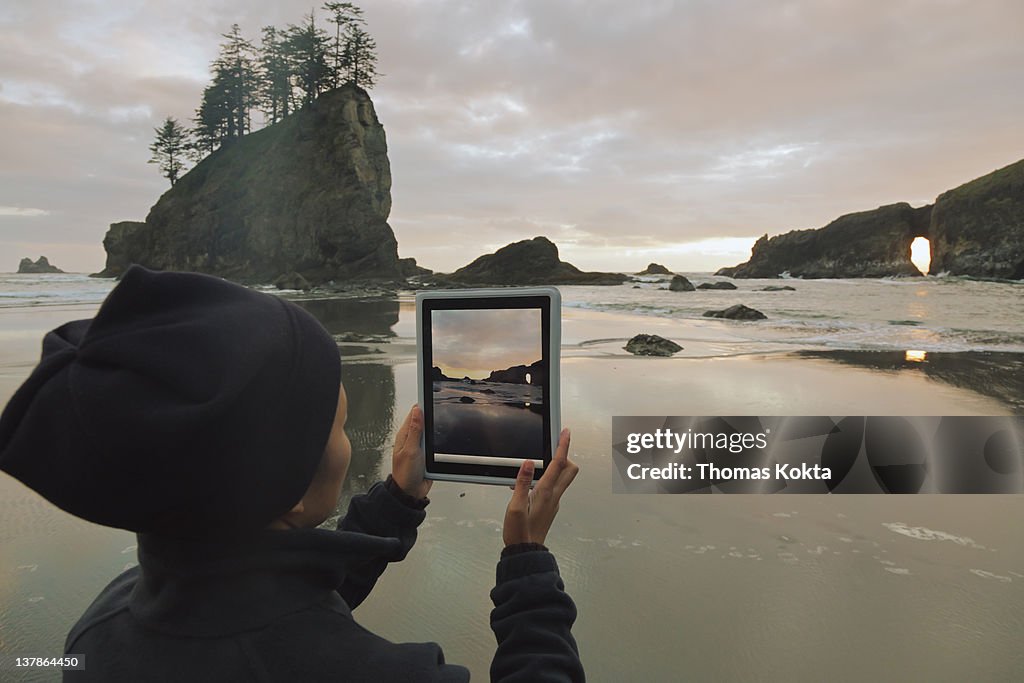 Person with tablet computer on the coast