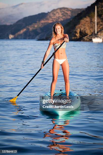 young girl stand up paddle boarding - sup stockfoto's en -beelden