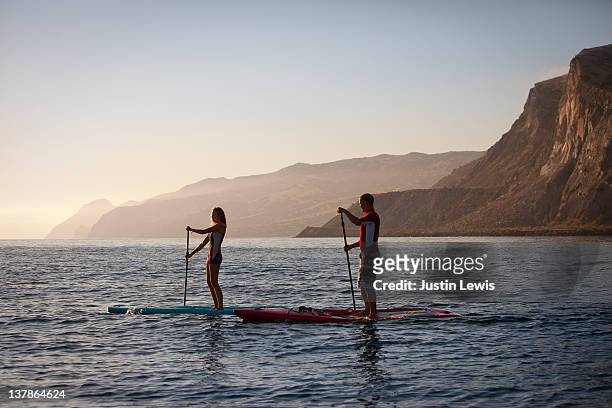 two stand up paddle boarders on misty morning - insel catalina island stock-fotos und bilder