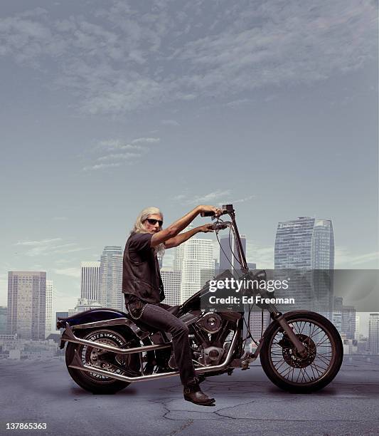 motorcycle rider with city background - hells angels stock-fotos und bilder