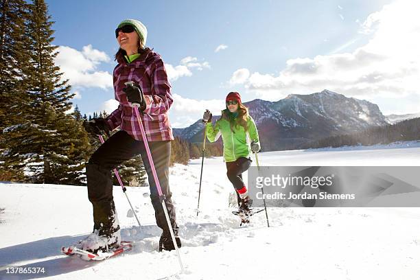 two females snowshoeing - sneeuwschoen stockfoto's en -beelden