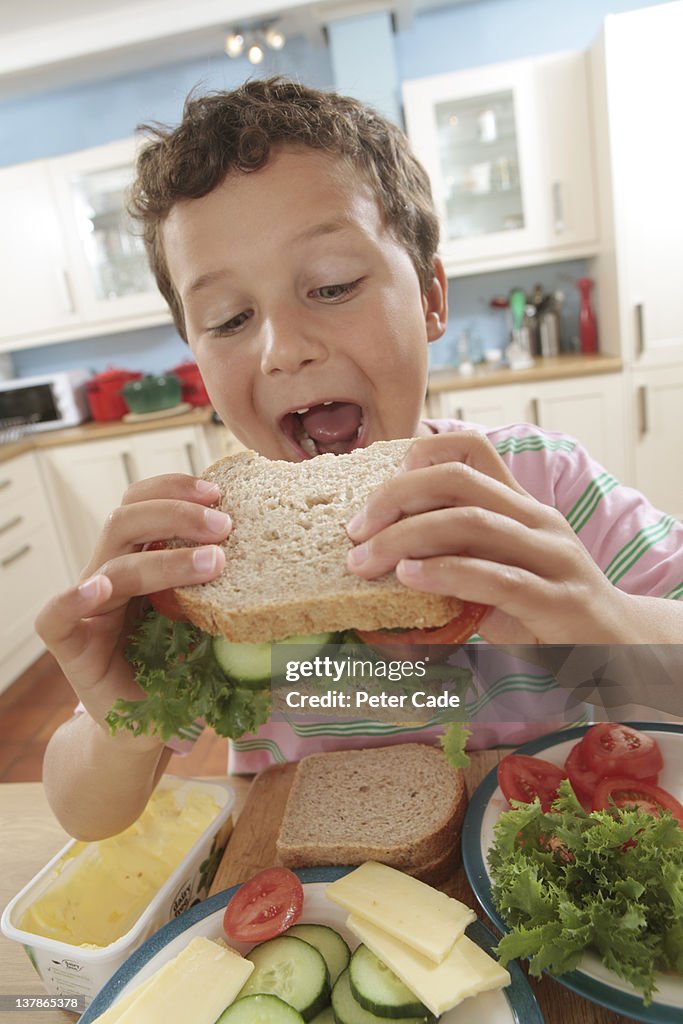 Young boy eating sandwich he has made