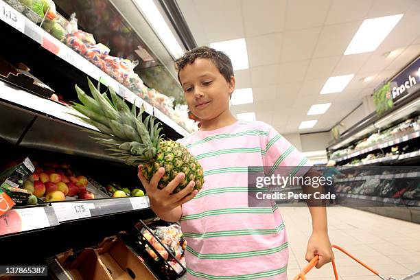 young boy shopping supermarket - supermarket uk stock pictures, royalty-free photos & images