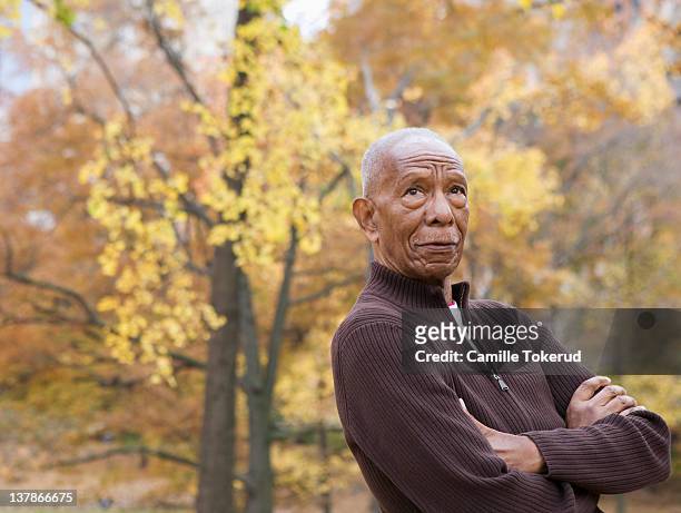 elderly man looking away with arms crossed - african american man day dreaming stock pictures, royalty-free photos & images