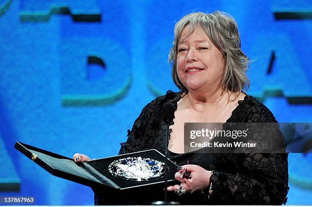 Actress Kathy Bates accepts the Feature Film Nomination Plaque on behalf of director Woody Allen for "Midnight In Paris" onstage during the 64th...