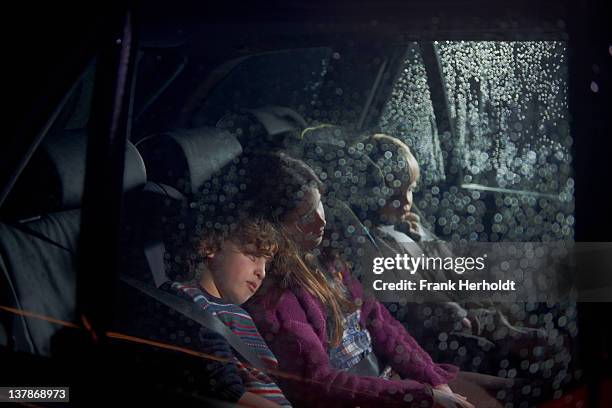 three children asleep in the rear seat of a car - girl rain night stock pictures, royalty-free photos & images