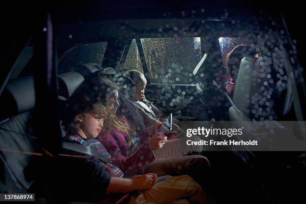 family in car at night - car interior side stock pictures, royalty-free photos & images