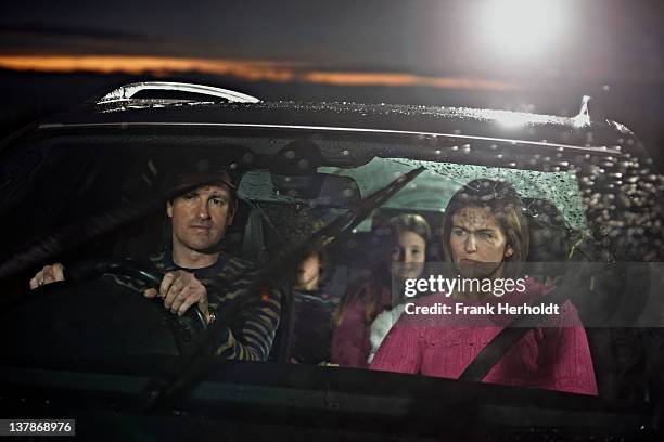 family driving in the rain at dusk - man driving anxiously stock-fotos und bilder