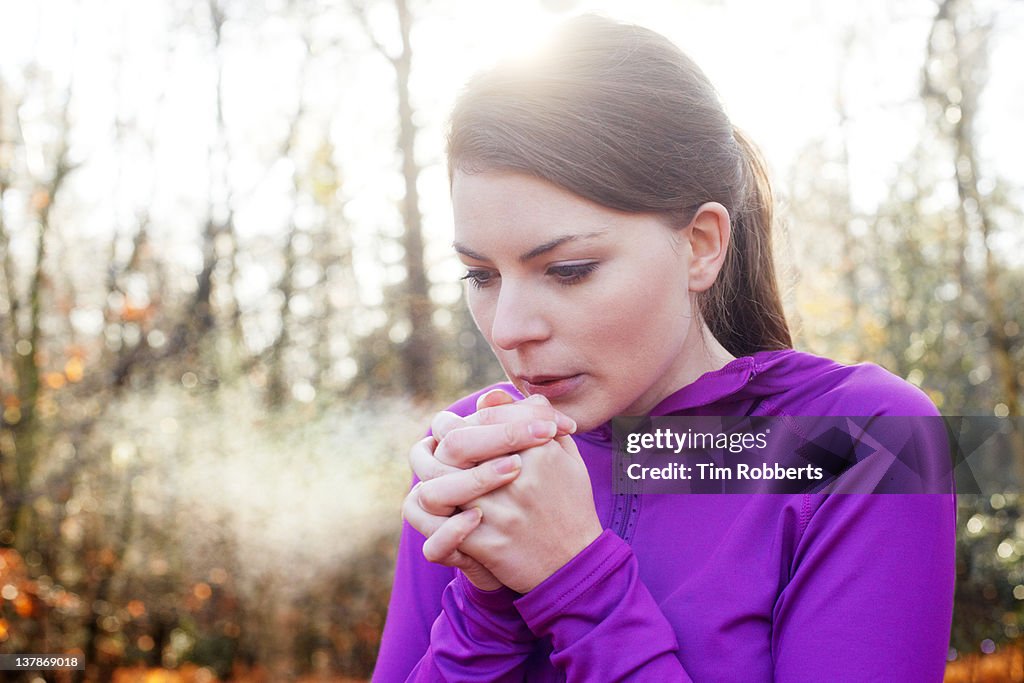 Woman warming hands on cold day.