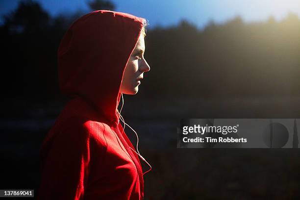 young woman in hooded top listening to music. - hood clothing stock pictures, royalty-free photos & images