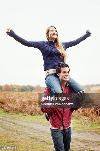 young woman on young mans shoulders. - sussex autumn stock pictures, royalty-free photos & images