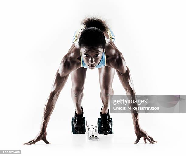 athletic female sprinter on starting blocks - sprint photos et images de collection
