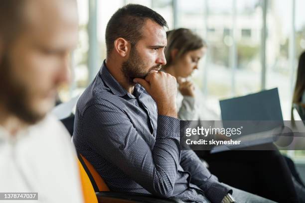 worried businessman on a seminar in board room. - boring meeting stock pictures, royalty-free photos & images