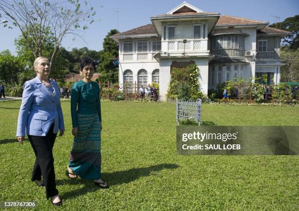 Pro-democracy opposition leader Aung San Suu Kyi and US Secretary of State Hillary Clinton tour the grounds after their meeting at Suu Kyi's...