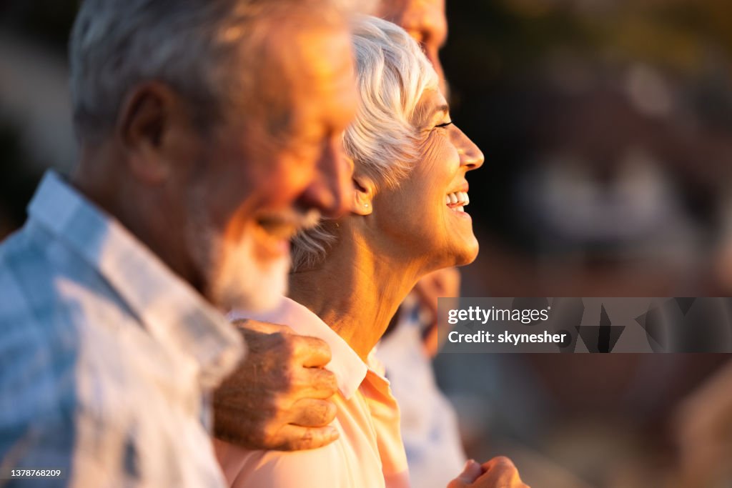 Happy senior woman walking with friends in nature.