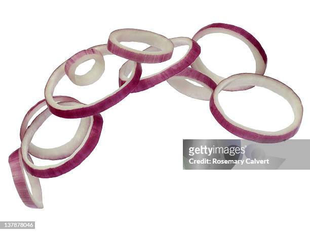 rings of red onion appearing to fly in formation. - red onion white background stock pictures, royalty-free photos & images