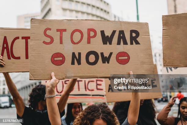 people are marching on strike against war - stop banner stock pictures, royalty-free photos & images