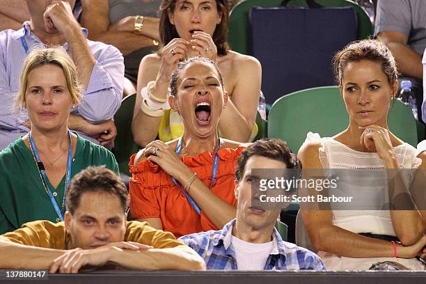 Erica Packer yawns alongside her nanny as they watch Novak Djokovic of Serbia and Rafael Nadal of Spain in their men's finals match during day...