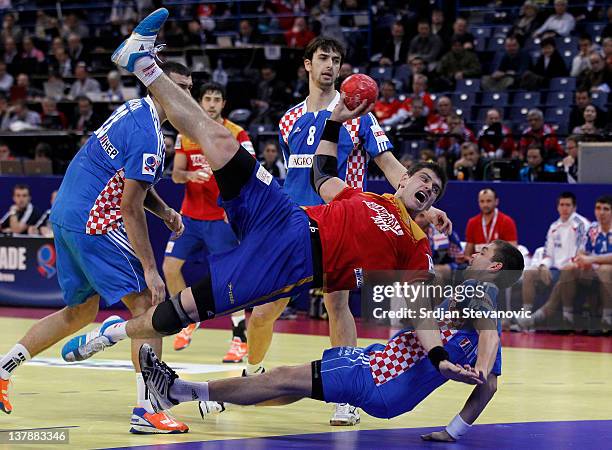 Julen Aguinagalde of Spain jumps to score past Drago Vukovic of Croatia during the Men's European Handball Championship 2012 Bronze medal match...