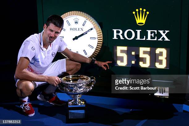 Novak Djokovic of Serbia poses with the Norman Brookes Challenge Cup and the clock after winning championship point and playing in the longest grand...