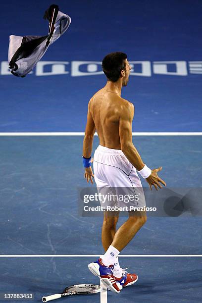 Novak Djokovic of Serbia rips his shirt off after winning championship point in his men's final match against Rafael Nadal of Spain during day...