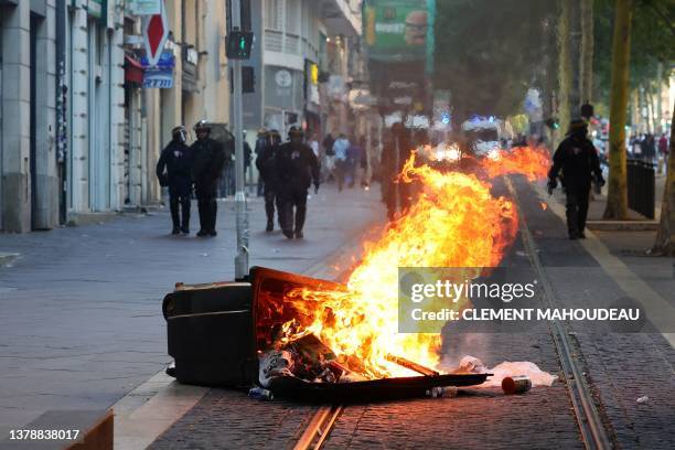 French riot police officers stand guard behind a burnt trash bin during a demonstration against police in Marseille, southern France on July 1 after...