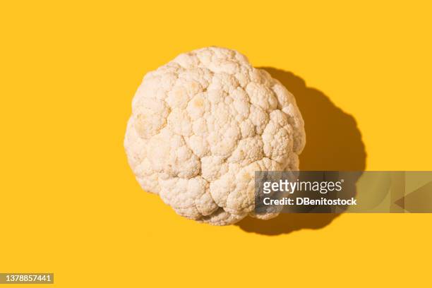 cauliflower with hard shadow on yellow background. organic food, cooking, agriculture and farming concept. - crudites stock pictures, royalty-free photos & images