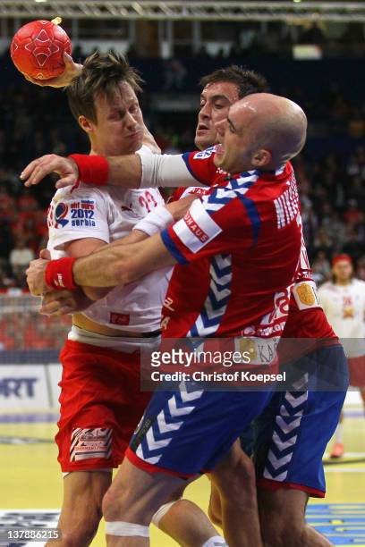 Ivan Nikcevic of Serbia and Momir Ilic of Serbia defend against Kasper Soendergaard Sarup of Denmark during the Men's European Handball Championship...