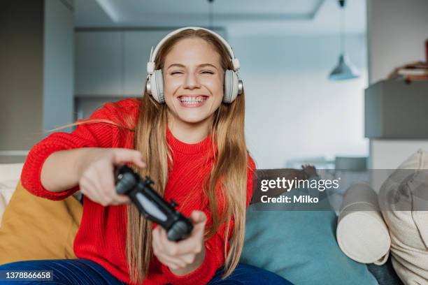 la jeune femme joue aux jeux vidéo à la maison - manette de jeu vidéo photos et images de collection