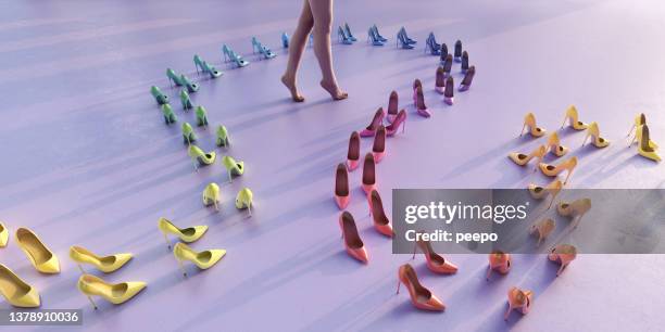 woman standing on tip toes surrounded by curving line of rainbow coloured high heels - purple shoe stock pictures, royalty-free photos & images