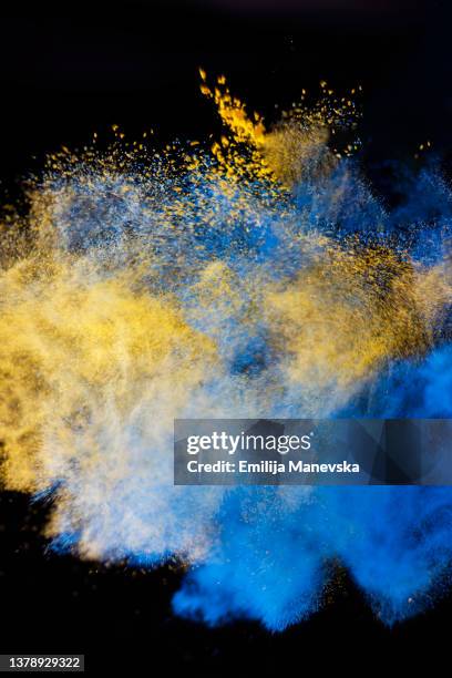 blue and yellow paint splash on black background - economic boom stock pictures, royalty-free photos & images