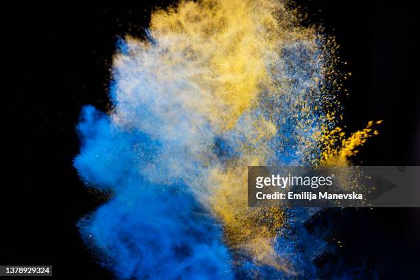 blue and yellow paint splash on black background - ukraine war stockfoto's en -beelden