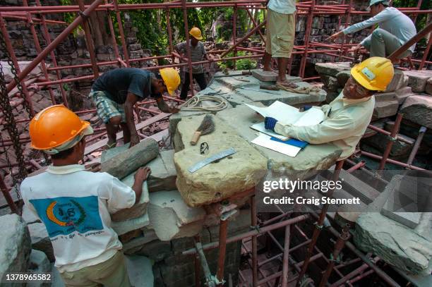 Khmer stone masons at work on the laterite stones at the Banteay Chhmar Temple, Banteay Meanchey, Cambodia on May 22, 2012. The stone masons and...