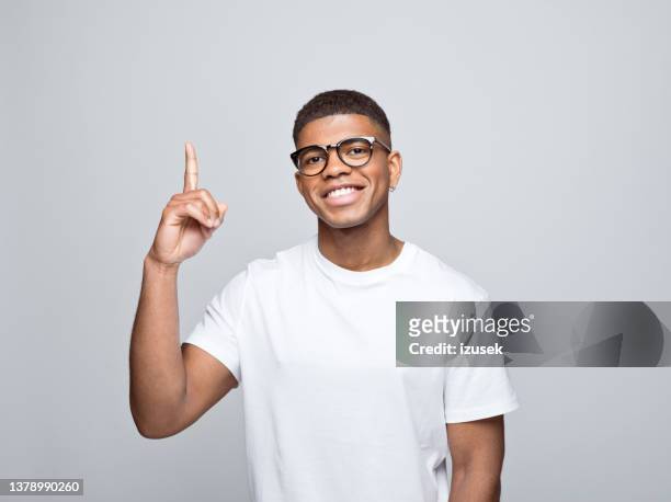 cheerful young man pointing at copy space - guy pointing stock pictures, royalty-free photos & images