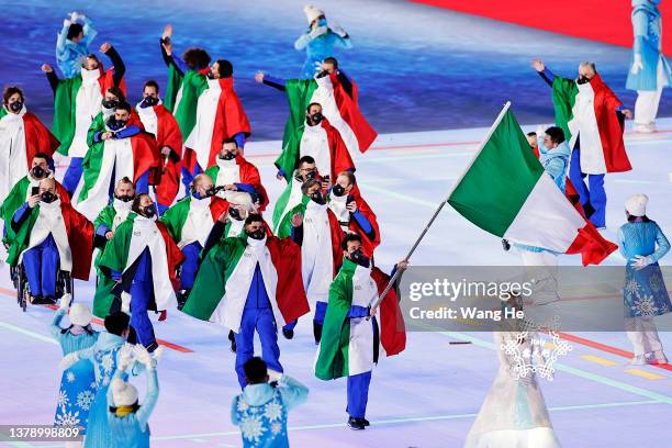Flag bearer Giacomo Bertagnolli of Team Italy leads their team out during the Opening Ceremony of the Beijing 2022 Winter Paralympics at the Beijing...