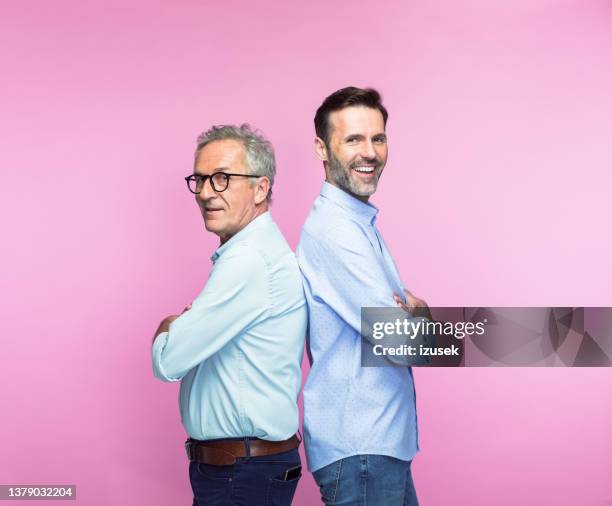 feliz padre e hijo de pie espalda con espalda - espalda con espalda fotografías e imágenes de stock