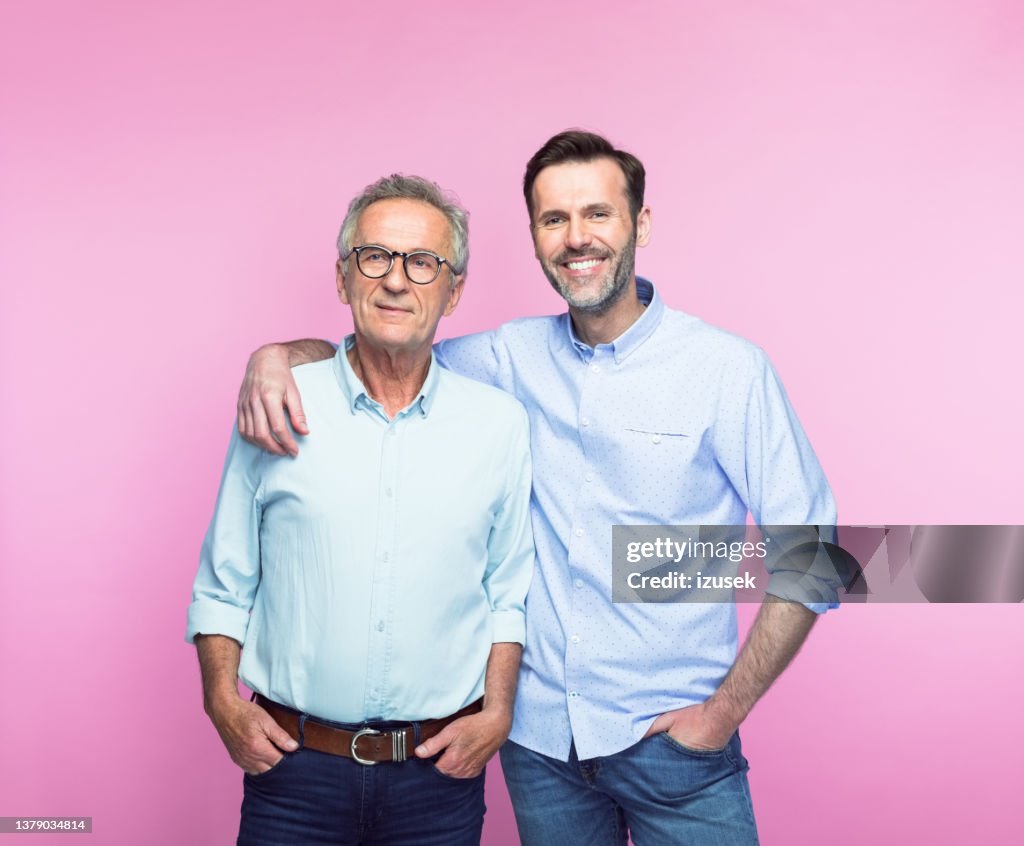 Smiling man with arm around senior father