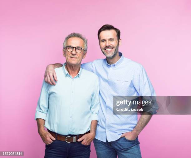 smiling man with arm around senior father - homens de idade mediana imagens e fotografias de stock