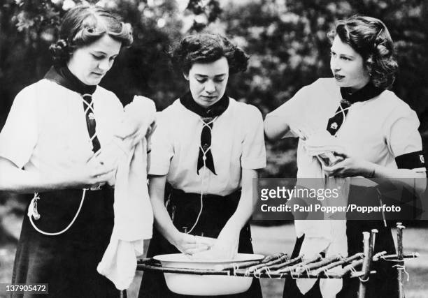Princess Elizabeth , helps with the washing up at a Girl Guides camp at Windsor, Berkshire, 25th July 1944. The princess is Patrol Leader of the...