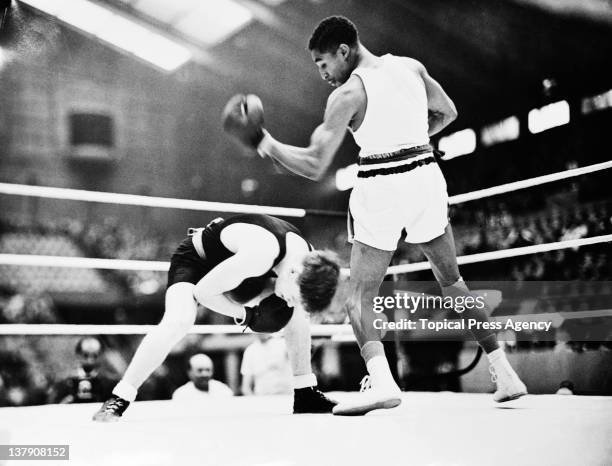 Bob Goslin of New Zealand ducks to avoid a punch from Eddie Johnson of the USA in match four of the featherweight boxing competition at Wembley,...